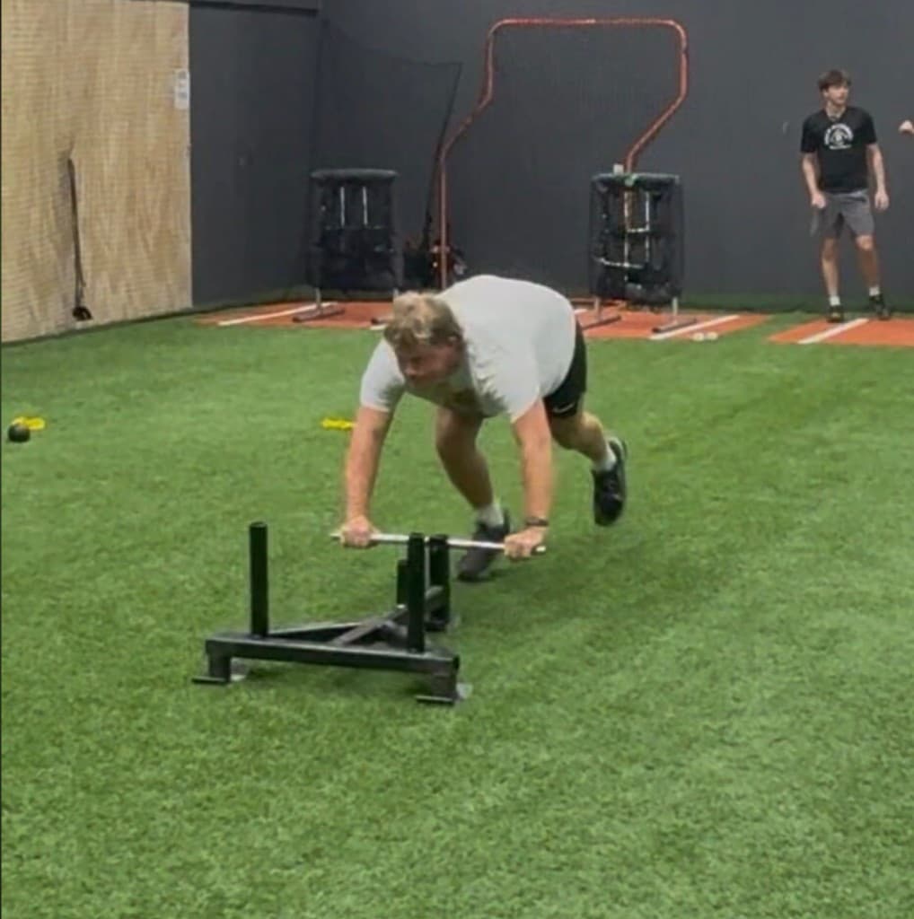 Athlete performing sled push strength training